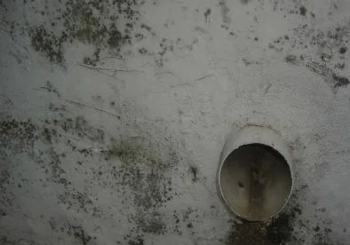 A white pipe sitting on top of a wall.