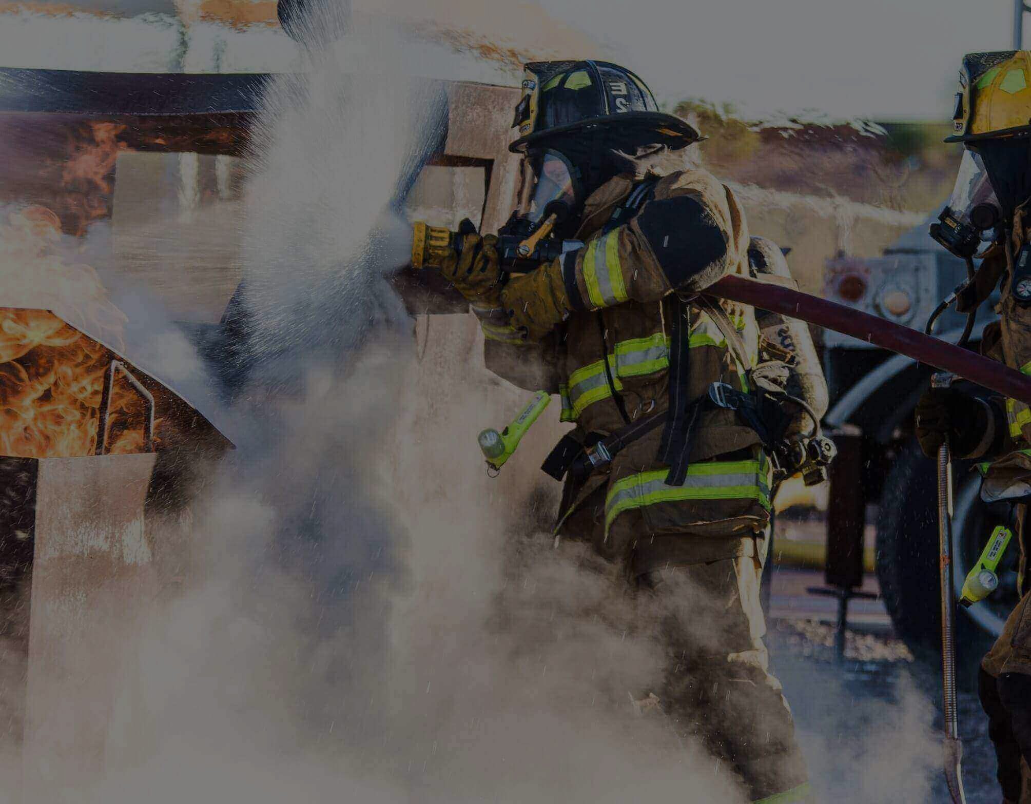 Firefighters battling a structure fire with smoke and flames