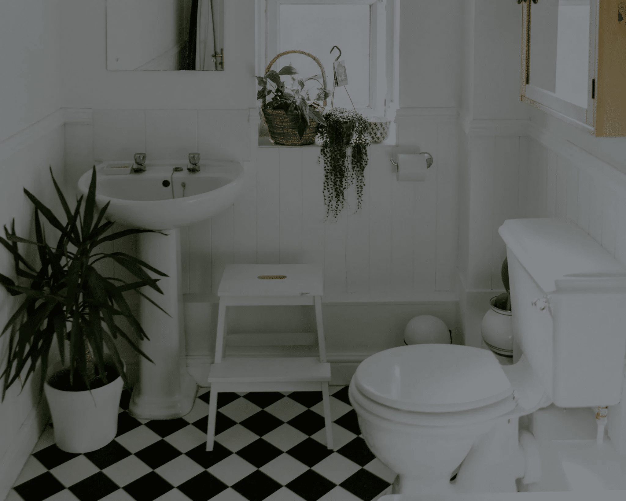 Bathroom with checkered tile floor, pedestal sink, and toilet