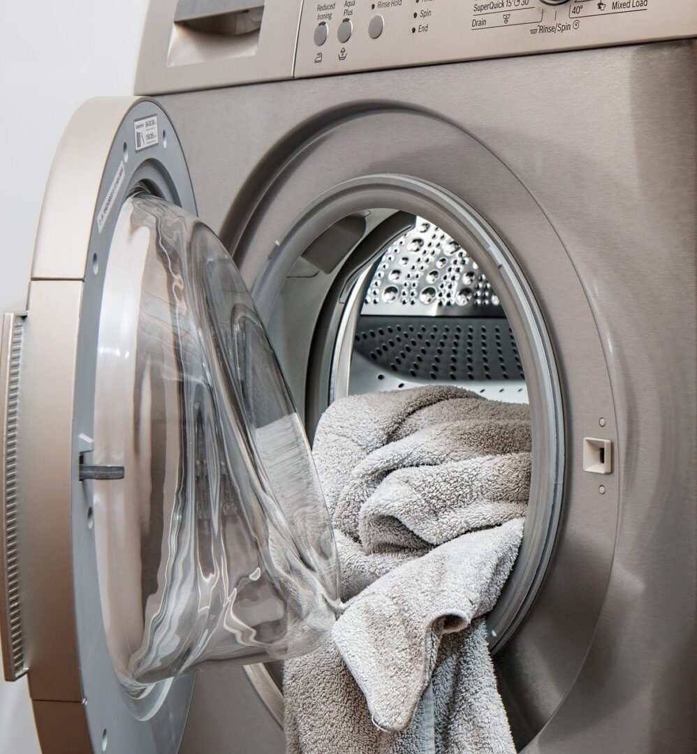 A washing machine with some folded towels in it